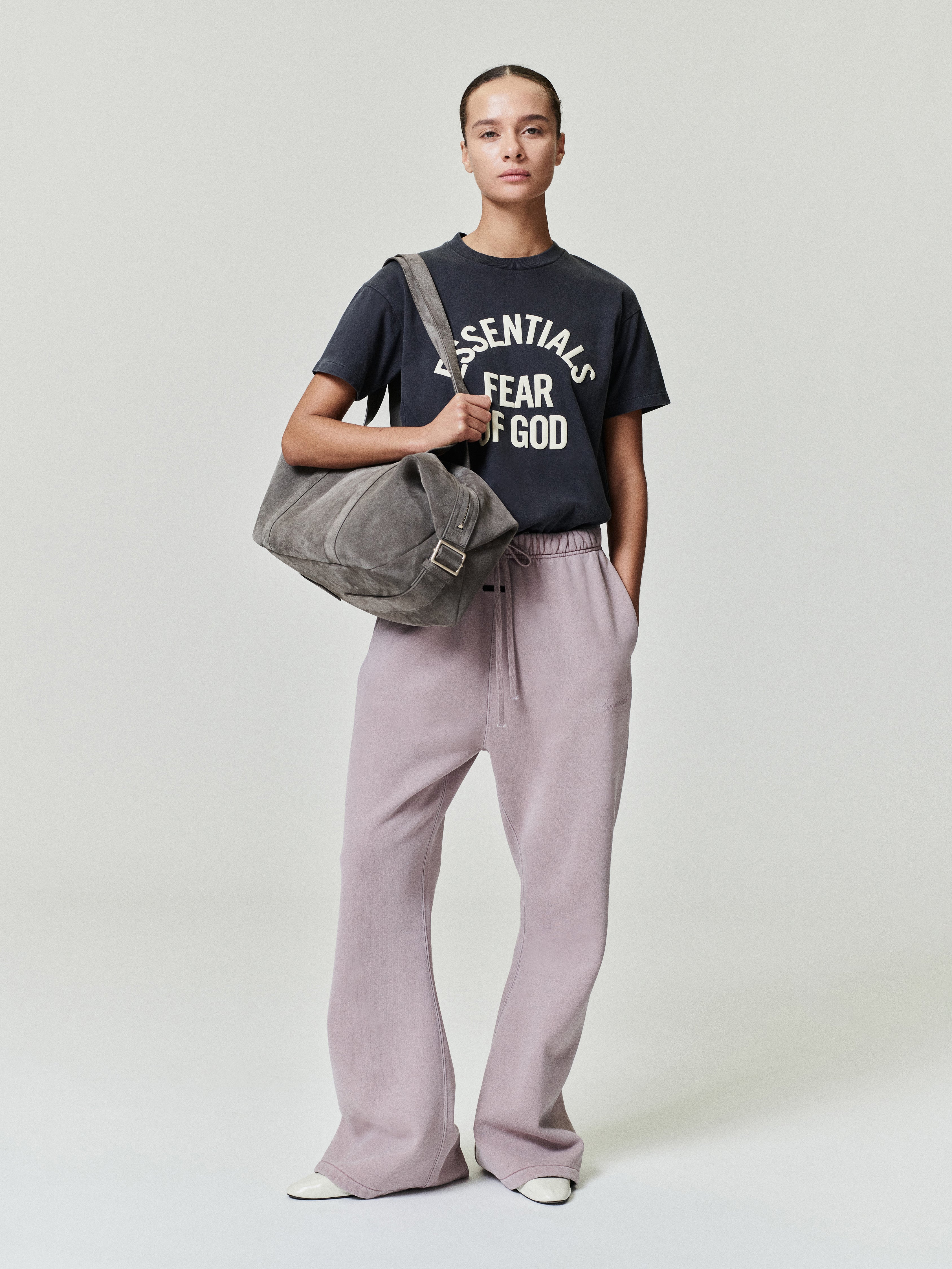female model wearing black pigment-dyed cotton jersey tee with crewneck and relaxed fit paired with lilac wide-leg pants