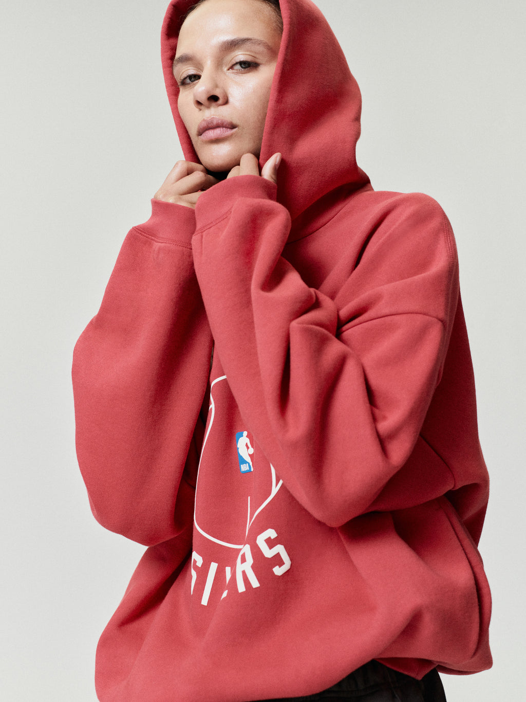 red oversized hoodie featuring puff-printed FEAR OF GOD SIXERS logo and NBA basketball emblem on front center