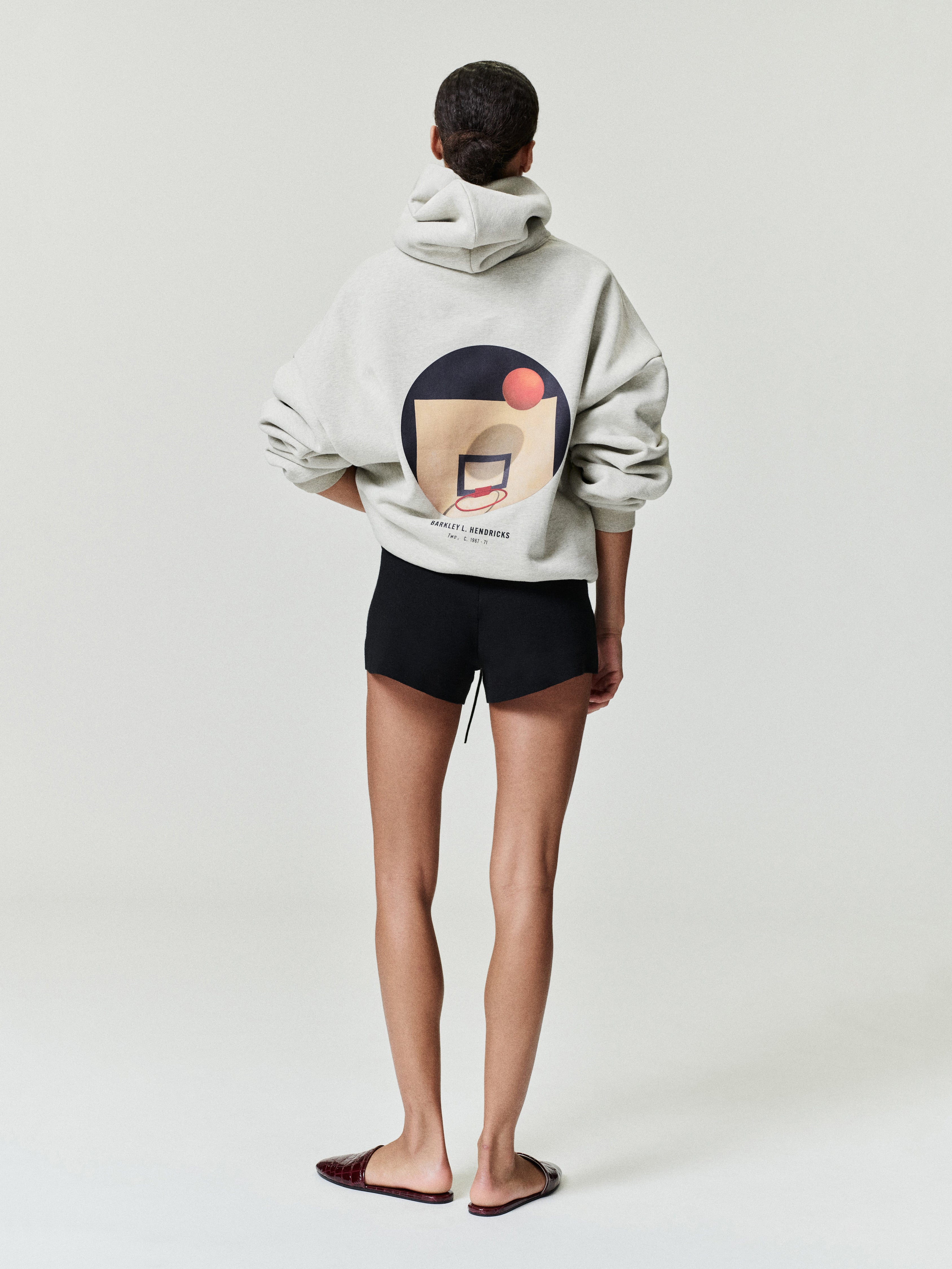 off-white heavyweight hoodie with abstract basketball hoop and Barkley Hendricks text on back worn by model facing away