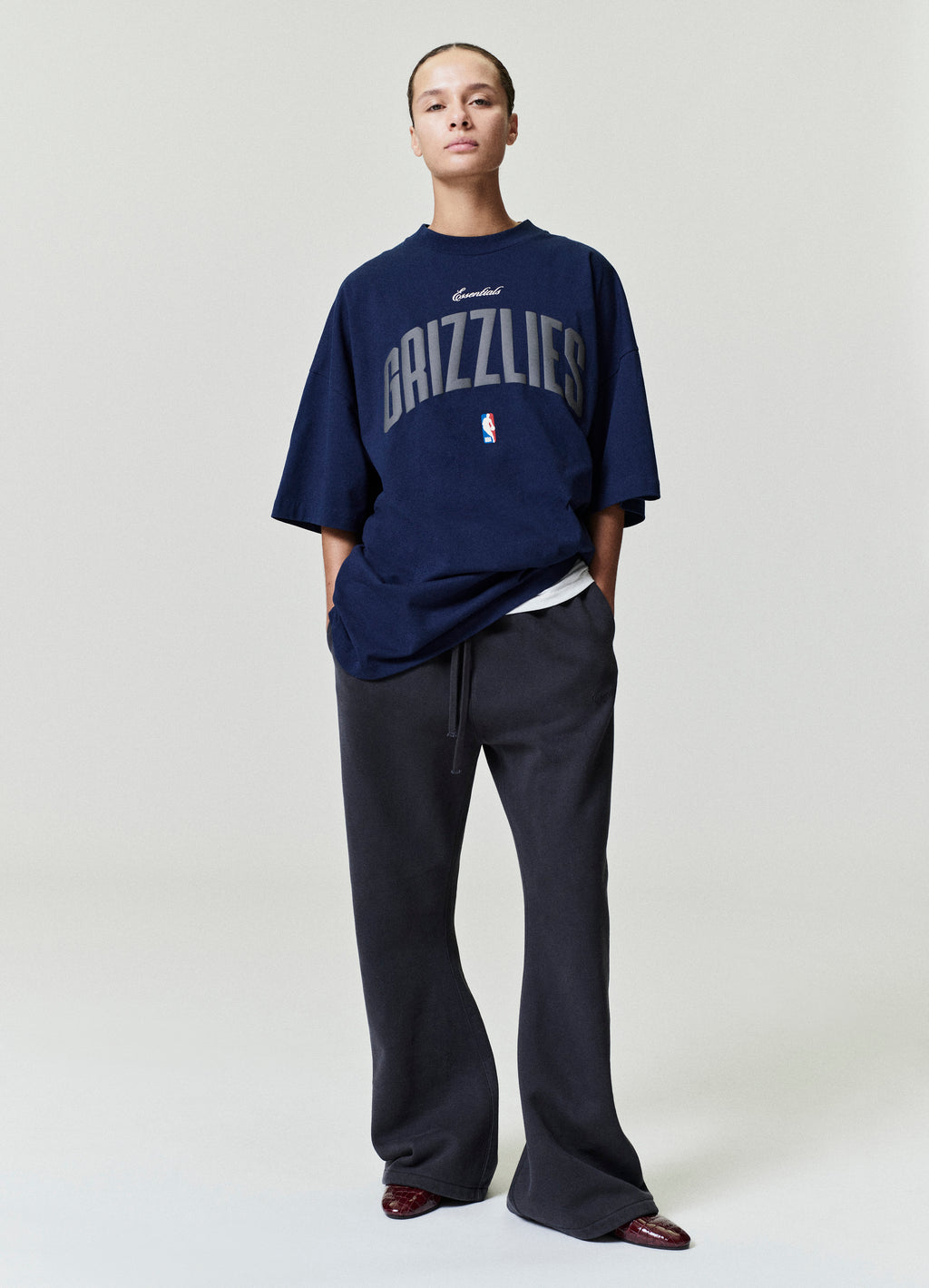 Model wearing navy Memphis Grizzlies 90's Fit Tee with large arched text and NBA logo, standing straight SP26_FW_L66-P_3236