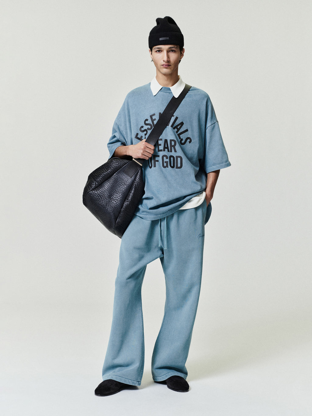 blue oversized 90s-style heavyweight cotton tee with ESSENTIALS FEAR OF GOD text, paired with matching relaxed pants