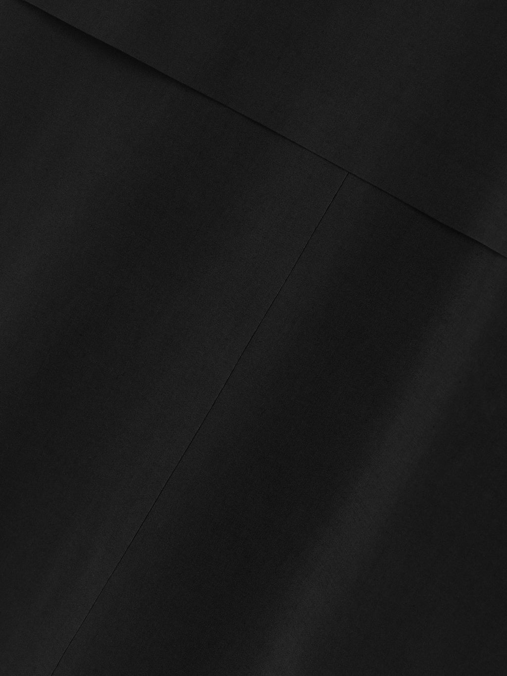 close-up view of smooth black stretch wool blend fabric with subtle seam detail on technical trench jacket