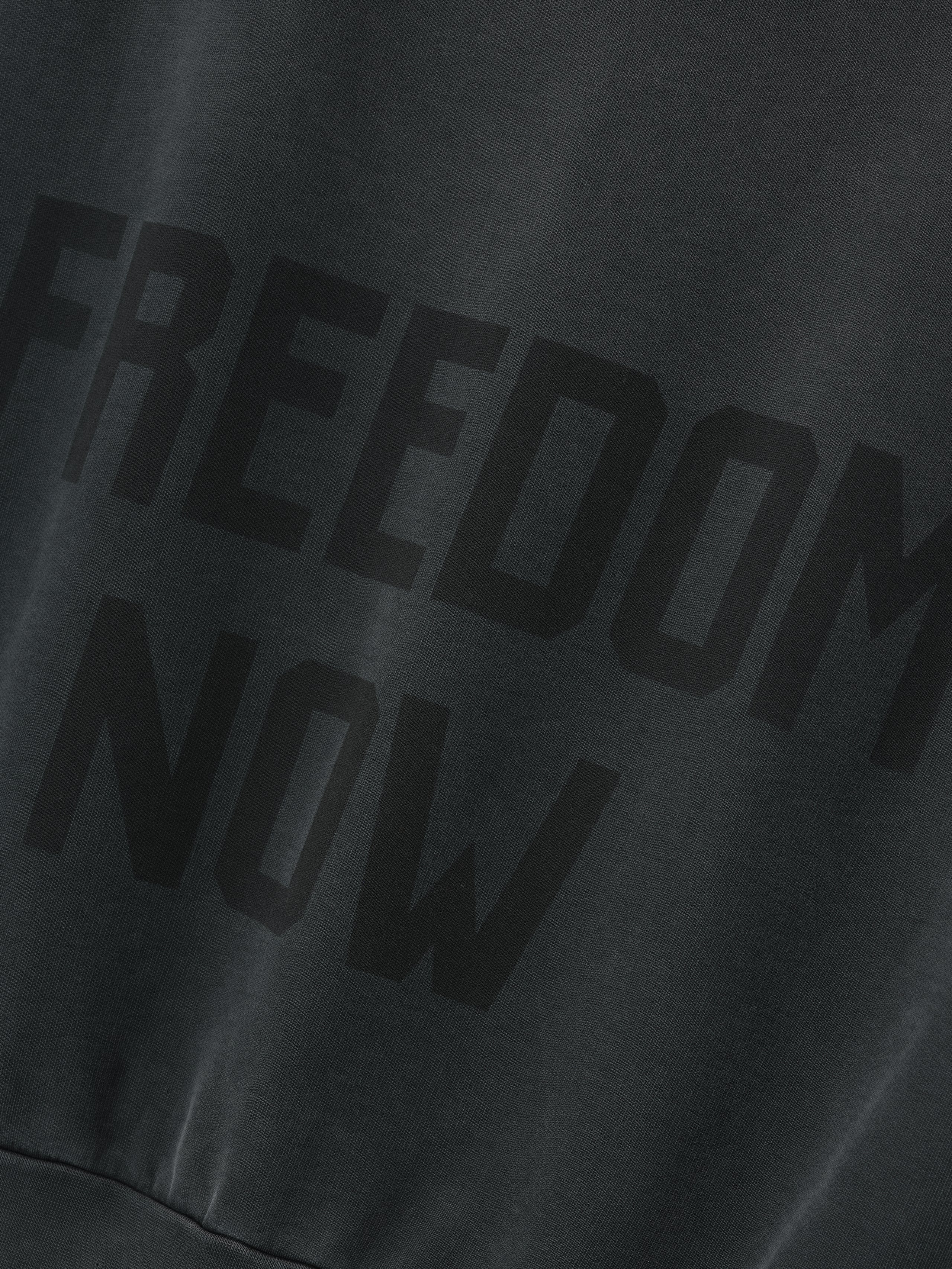 Vintage Power 25 Hoodie in washed black with large tonal "FREEDOM NOW" text printed on the back, crafted from soft fabric for comfortable outerwear.